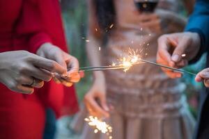 People holding sparklers and holding them up photo