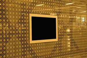 A black square frame is mounted on a wall photo