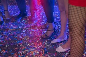 A group of people standing on a dance floor with confetti photo