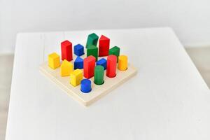 A wooden toy with colorful blocks on top of a table photo