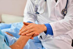 A doctor holding the hand of a patient photo