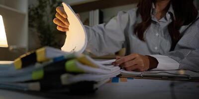 Late Night Paperwork. Close-up of hands sorting through documents in an office. photo