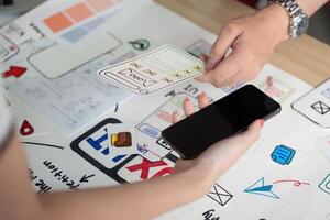 UX and UI Design. Hands interacting with smartphone and design elements for app development. photo