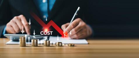 Business cost reduction strategy concept with stacked coins and red downward arrow, showing financial management, percentage decrease, budgeting, expense control, and company savings improvement photo