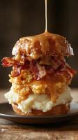 A towering sandwich made with two glazed donuts, crispy bacon, fried chicken, and a drizzle of honey. The dish is served on a black plate. photo