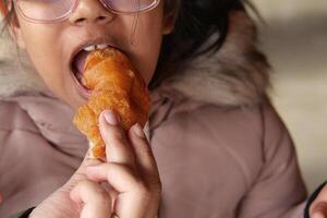 Child enjoys a pastry in a cozy setting photo