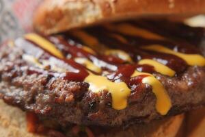 Delicious burger served with barbecue sauce and mustard photo