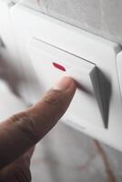 Finger pressing light switch in modern interior setting photo