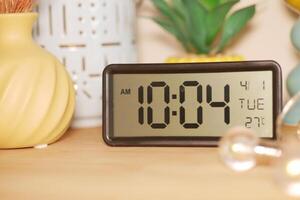 A digital clock shows 10.04 AM on a Tuesday in a warm room photo