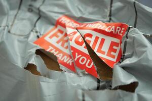 Delivery package showing damage with fragile notice photo