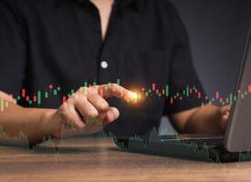 Stock exchange market analysis. A businessman or trader pointing to a graph stock on a virtual screen photo