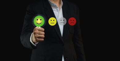 Choosing a green happy mood icon rating review in the survey of customer satisfaction on a virtual screen. photo