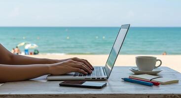digital nomad working on a laptop at a beach cafe. with a laptop and coffee photo
