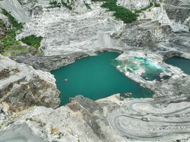 Open pit mine industry. Limestone quarry with truck in operation. Mining industry and construction material supply. Landscape of resource extraction in a industrial site. Gravel and cement production. photo