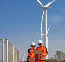 Engineers reviewing plans at wind farm photo