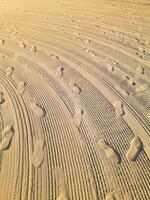 Sand Patterns and Footprints on a Sunny Beach photo