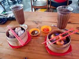 Dim Sum and Chocolate Drinks A Culinary Delight on Wooden Table photo