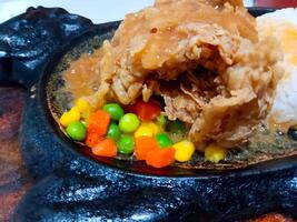 Sizzling Chicken Steak with Vegetables and Rice on Hot Plate photo