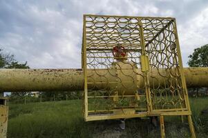 Protective structure of gas pipeline in fenced area on summer day. Part of gas pipeline control point in the middle of field. Industrial installation in open air. Concept of ecological safety photo