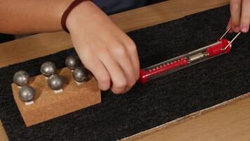A hands-on physics experiment using a spring scale to measure friction and force on a weighted block over carpet video