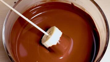 Banana slice dipped into smooth, melted chocolate video