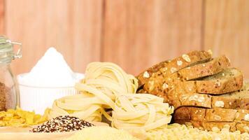 A hand selects tagliatelle from a display of bread and grains. Bright lighting, wooden background, and a warm, inviting atmosphere video