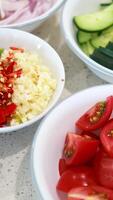 Colorful vegetables and spices arranged in bowls on a kitchen counter, ready for salad preparation video