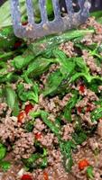 Close-up of beef and basil stir-fry in a wok, vibrant colors, dynamic spatula movements, bright lighting video