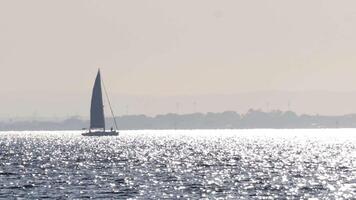 Sailboat sailing on shimmering ocean waters video
