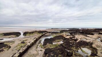 Rocky shoreline with distant sandy beach video