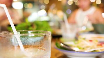 A vibrant Vietnamese restaurant scene with iced drinks and dishes, capturing a lively dining atmosphere with blurred background video