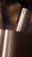 A detailed view of a milk frother steaming milk, highlighting the frothing action and steam in a warm kitchen setting video