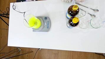 Overhead view of a chemical reaction involving iodine, vitamin C, and starch on a lab table video