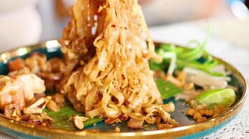 Close-up of Pad Thai being served with shrimp and lime in a vibrant Bangkok setting. Warm lighting enhances the appetizing presentation video