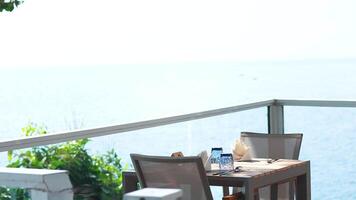 A serene dining setup overlooking the ocean, captured in bright daylight with minimal movement video