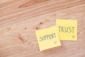 Support and trust in teamwork office space text notes professional setting top view team collaboration photo
