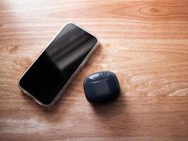 Mobile device and wireless earbuds home setting product minimalist style close-up view technology appeal photo