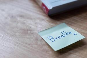 Mindful reminder breathe note desk home office still life calm environment close-up perspective photo