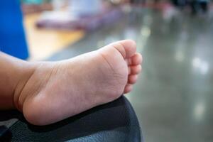 Toddler's playful foot touching soft surface indoor play area close-up vibrant environment photo