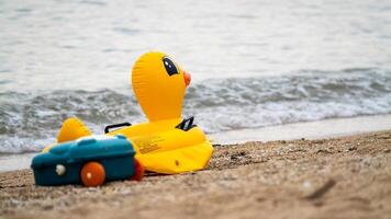 Beach scene with inflatable duck and toy coastal relaxation nature serene environment photo