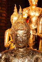 Golden buddha statues display cultural temple art indoor setting close-up perspective photo