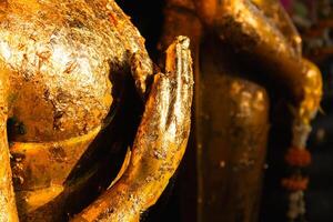 Golden buddha statue offering in tranquil temple setting cultural heritage close-up perspective photo