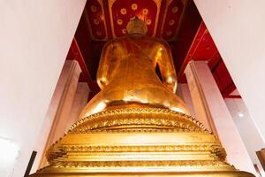 Golden buddha statue temple in thailand cultural icon serene environment rear view spiritual significance photo