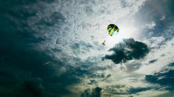 Daring paragliding adventure coastal beach action shot dramatic sky aerial view thrill-seeking experience photo
