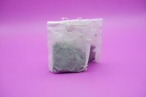 Dry Tea Bags Isolated on Colorful Surface photo
