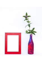Blank picture frame and flower in motley vase. photo