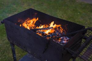 Smoldering coals in the grill. Coals in the grill. Evening in the village photo