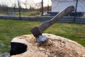 The axe is hammered into an oak block. The axe is stuck in the deck photo