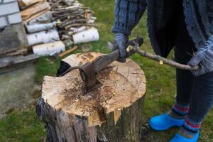 Cutting branches on the deck. girl cuts a branch with an axe photo