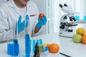 Scientist studying fruit in laboratory setting photo